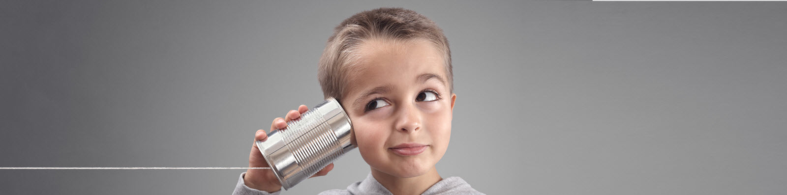 boy listening into a metal can with a string